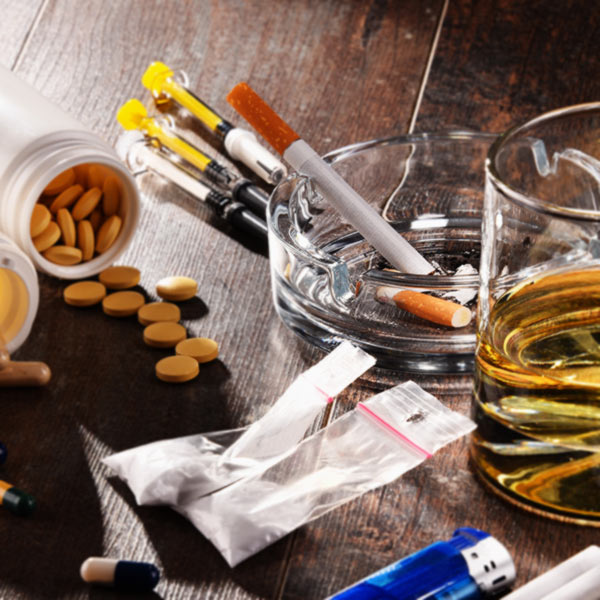 Cigarettes, pills, alcohol, drugs on table